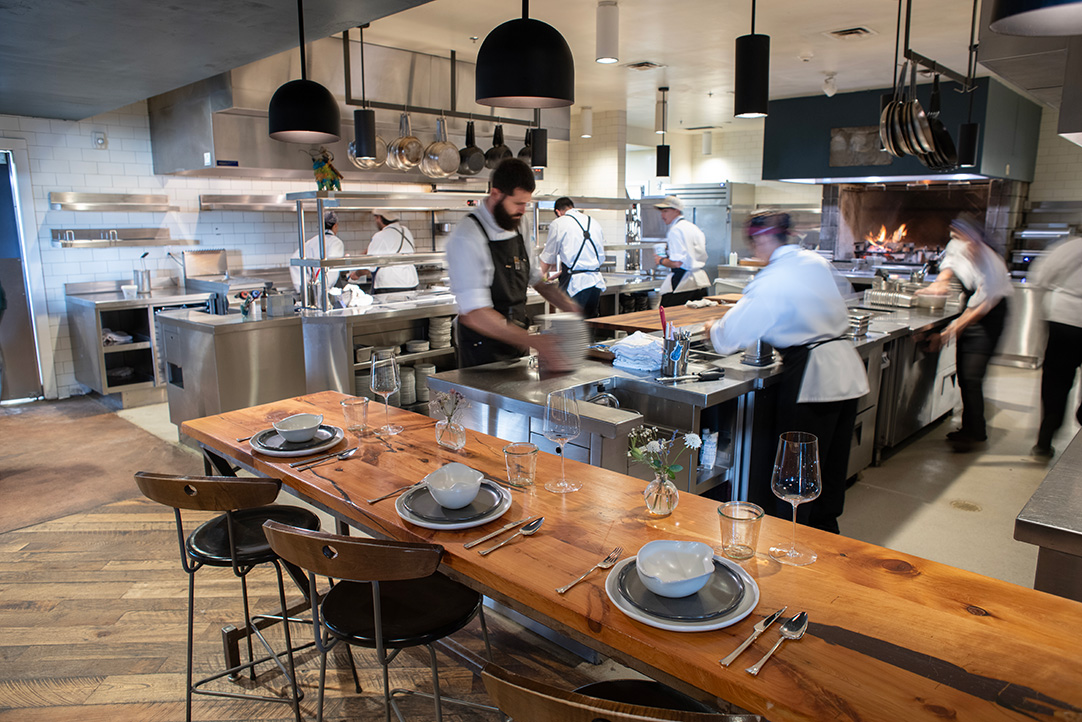 chef's table in front of the bustling kitchen