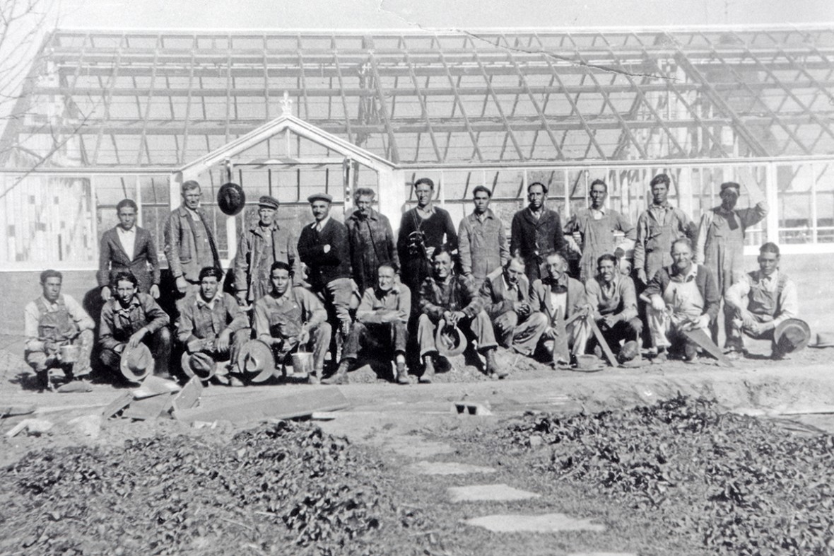 A group of workmen posing for a photo in front of a Lord & Burnham greenhouse that they built
