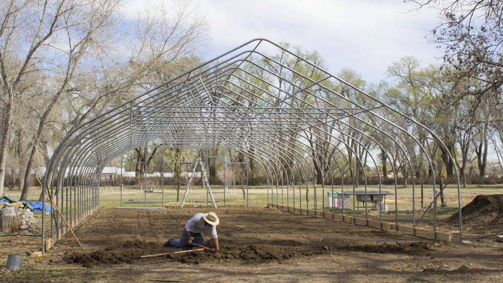 Farmer Max digging trenches for the new high tunnel greenhouse.