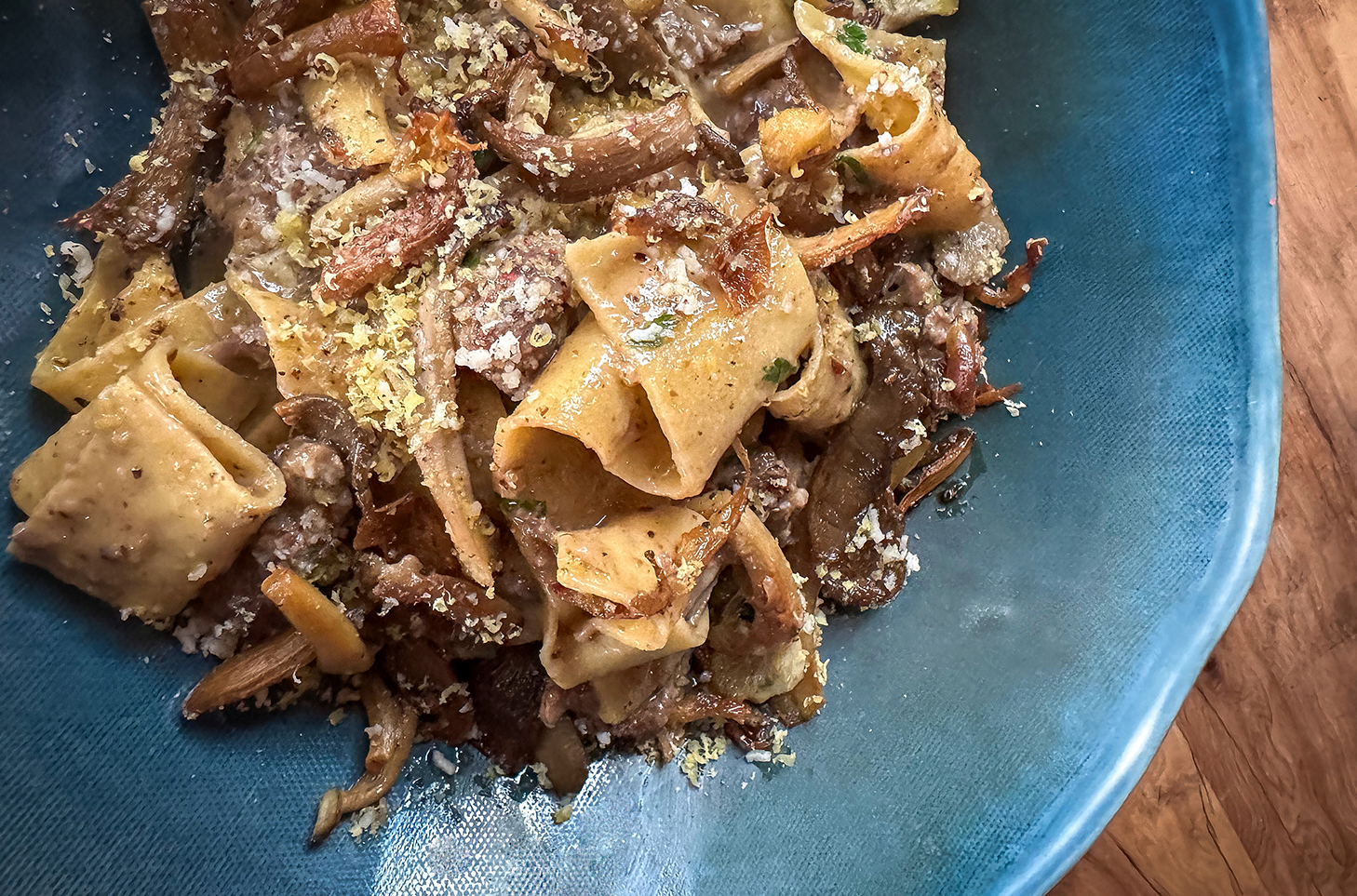 peppercorn lamb pappardelle dish on blue ceramic plate